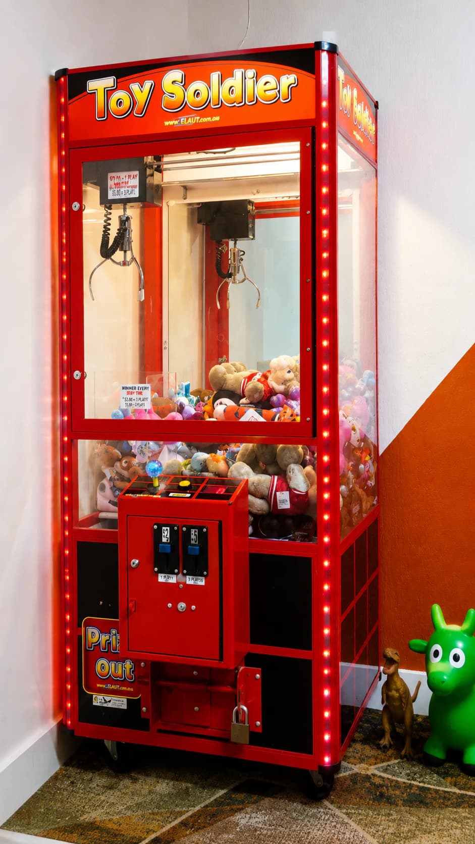 The red toy claw machine in the family play area